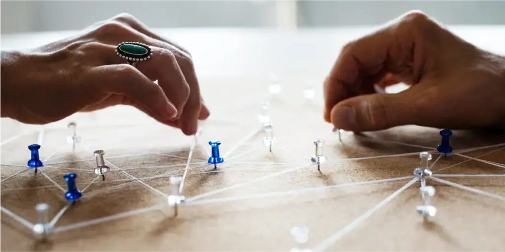 Hands arranging pins on a board