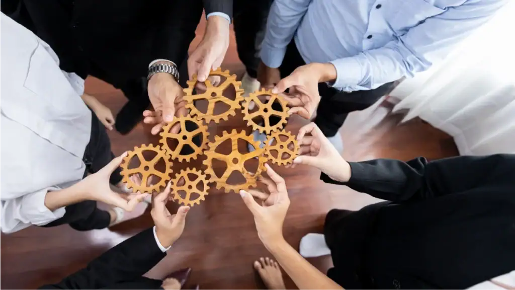 Hands collaborating with interlocking gears